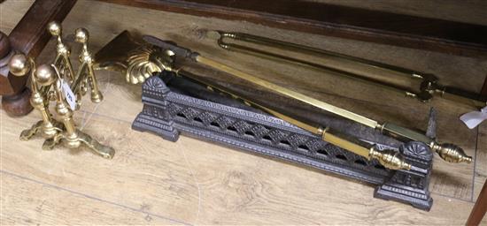 A set of three brass fire irons, the handles of square tubular section, with turned finials and a pair of rests